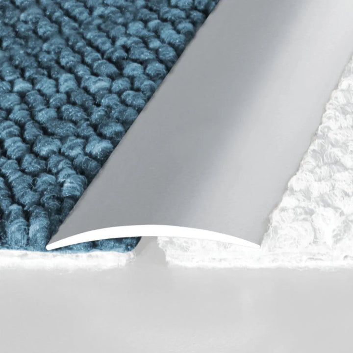 A13 40mm aluminium wood effect self adhesive door threshold strip fitted between two floor surfaces in a UK home doorway.